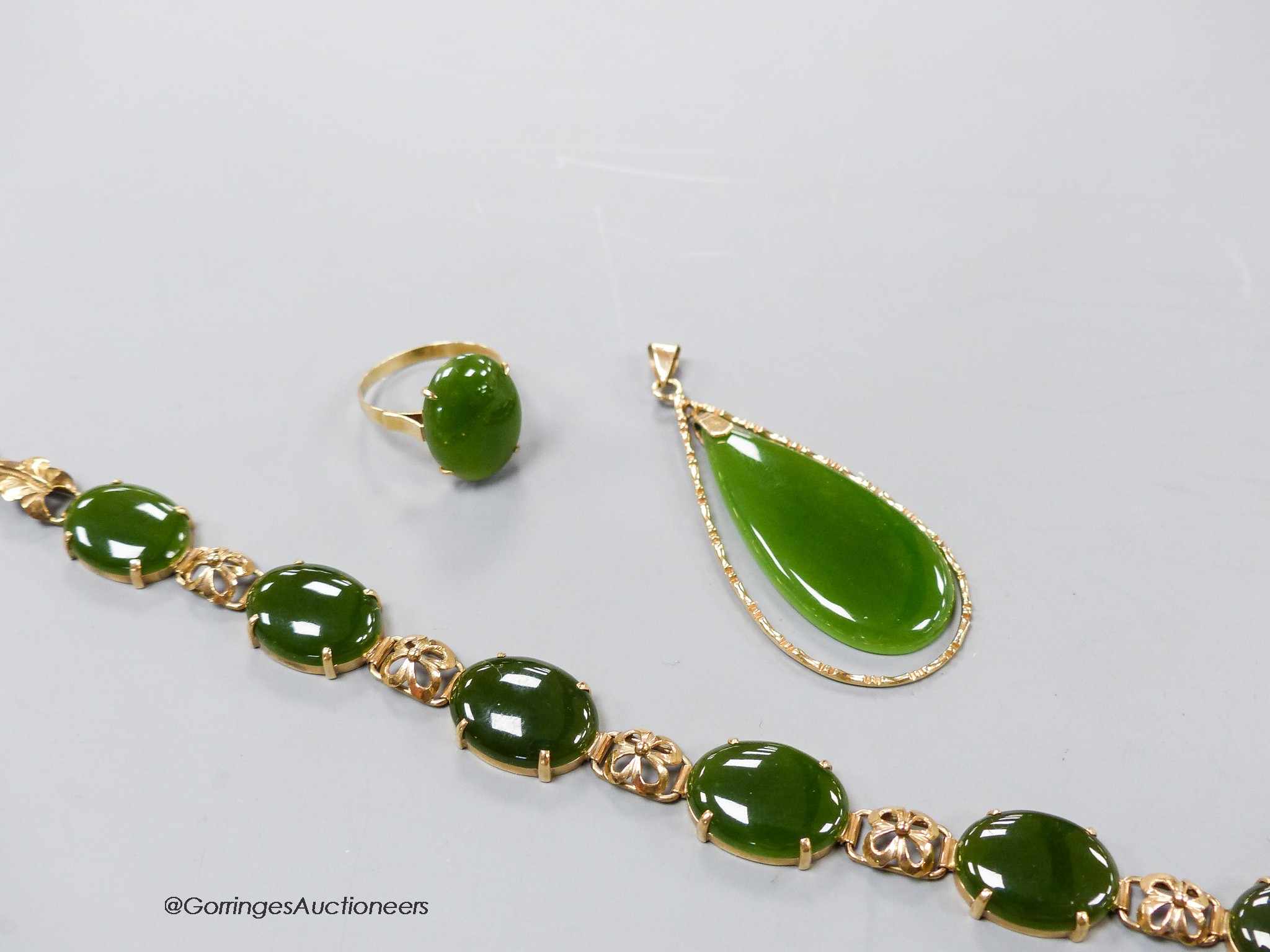 A 14k yellow metal and cabochon jade set bracelet, 18.5cm, gross 13.3 grams, an 18k mounted jade pendant and dress ring, gross 8.5 grams.